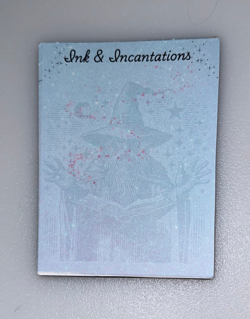 Notepad with wizard casting spells — “Ink & Incantations” desigb