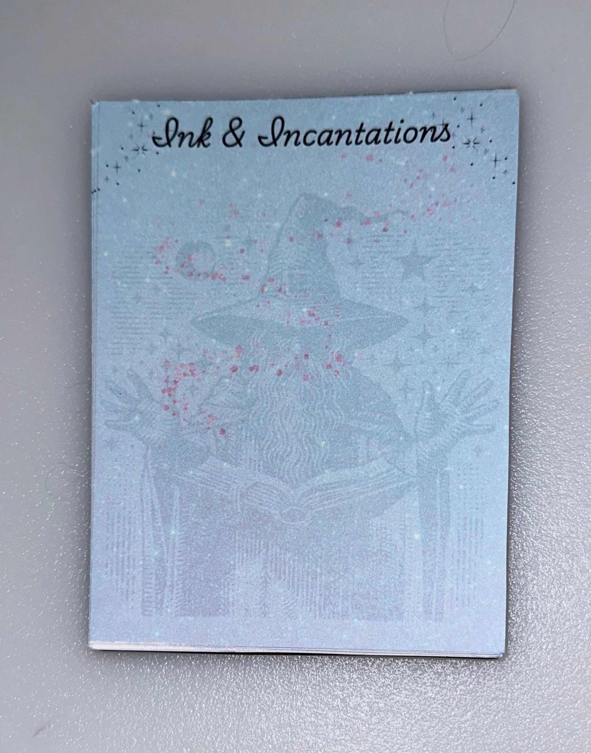 Notepad with wizard casting spells — “Ink & Incantations” desigb