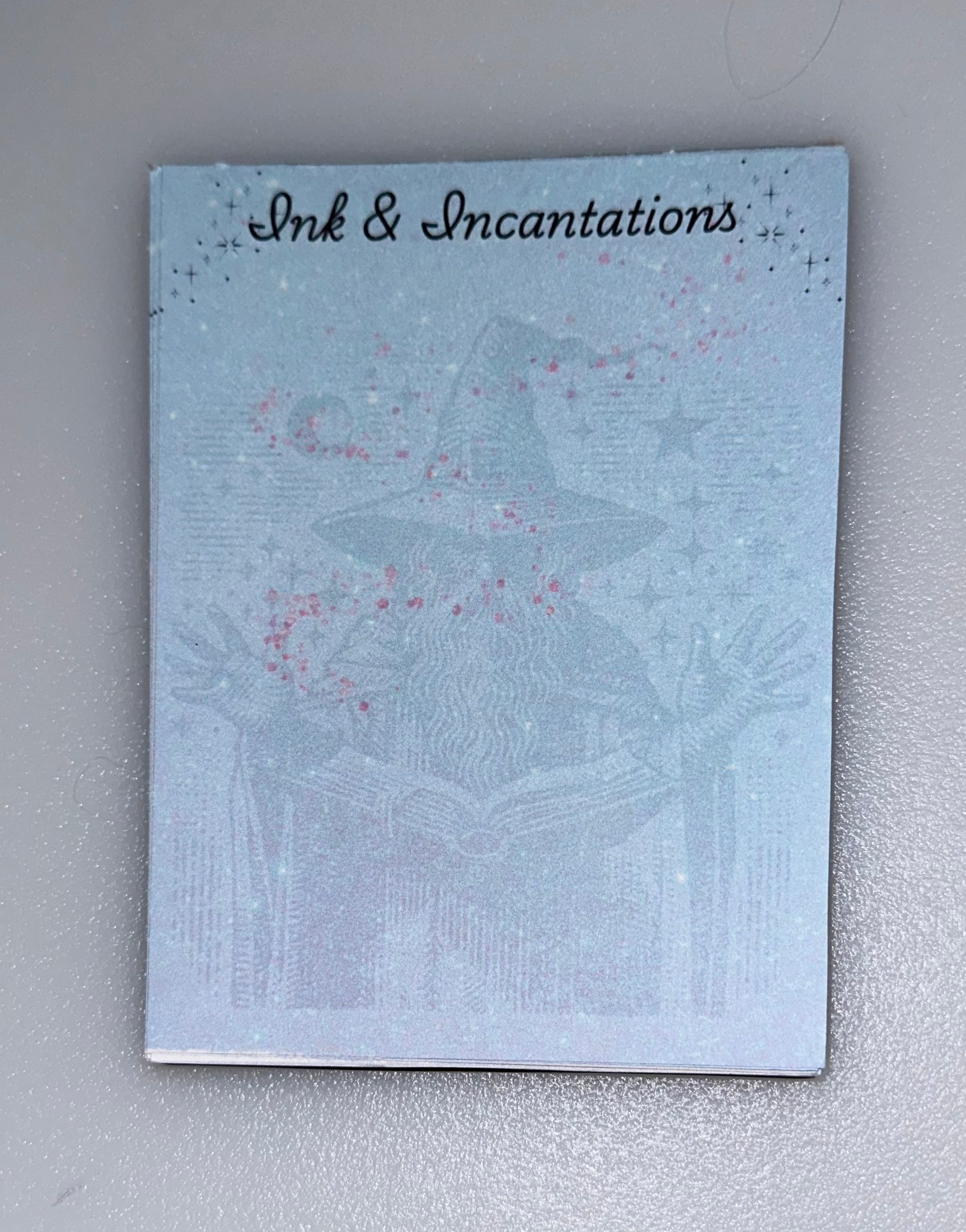 Notepad with wizard casting spells — “Ink & Incantations” desigb