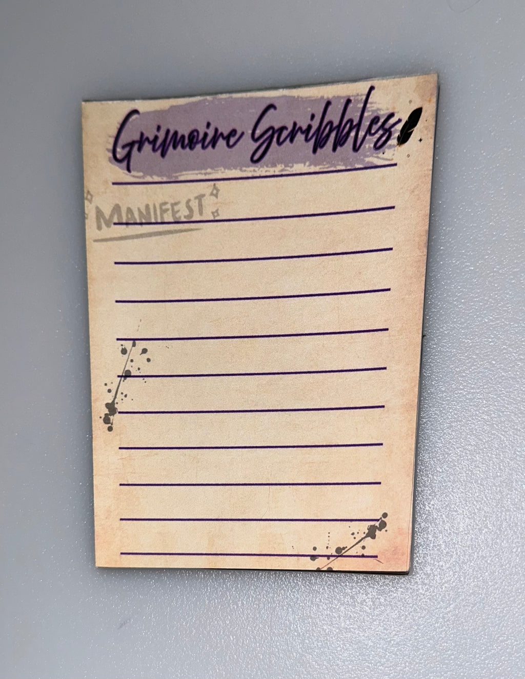 Grimoire Scribbles notepad with purple lines and ink blot corners